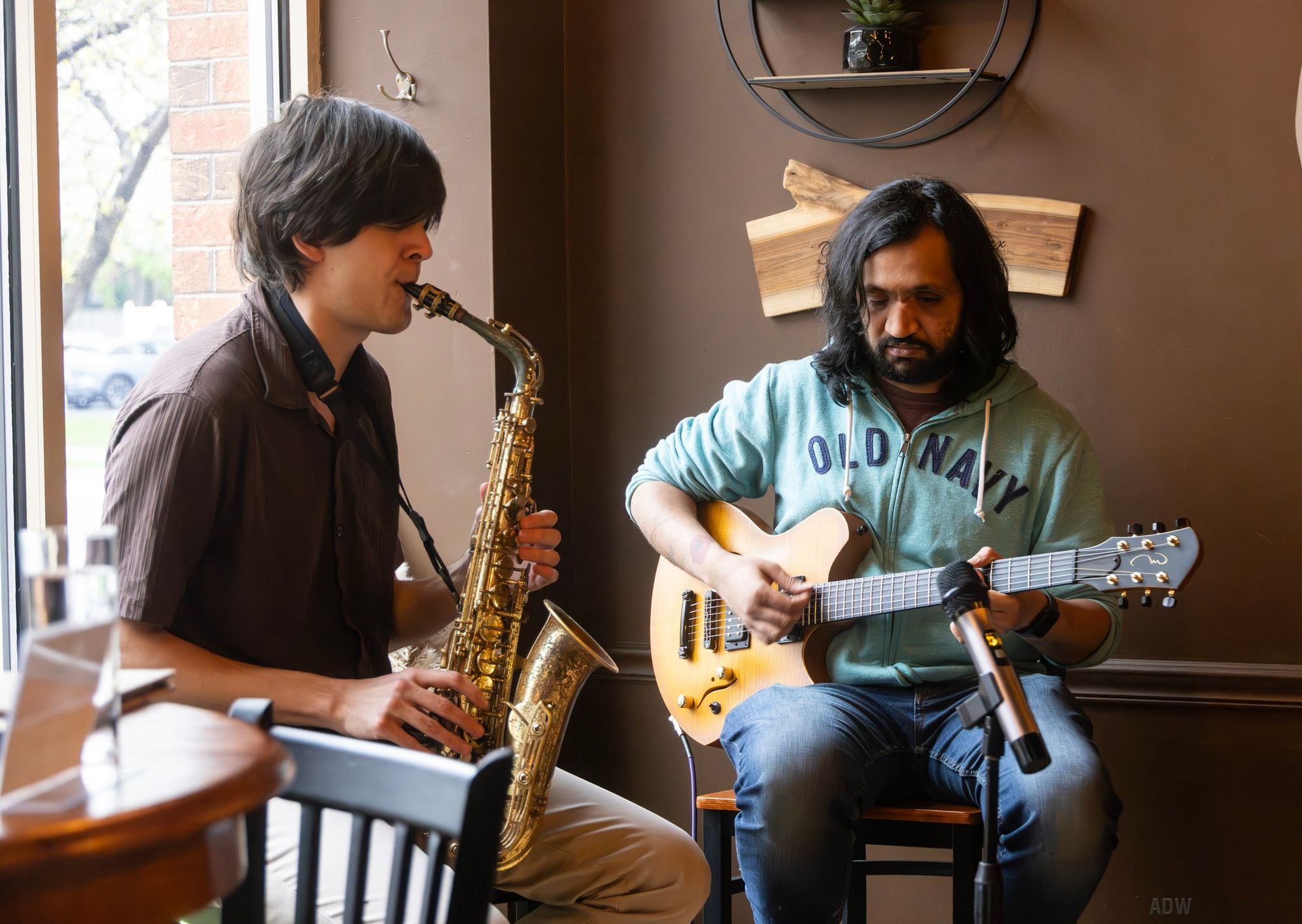 Eshaan sood and a saxophone player performing in a cafe